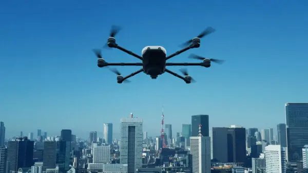 A shot of a drone flying with a the city in the back