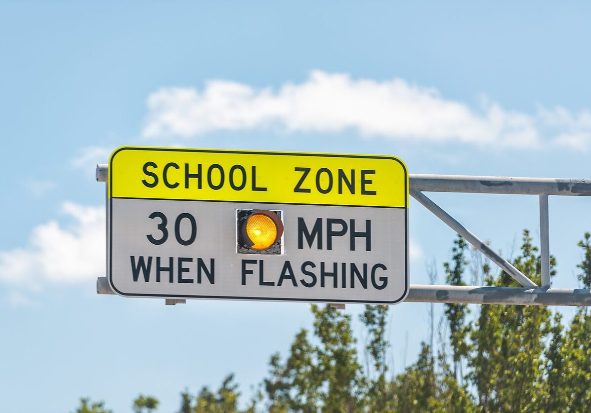 Public School Zone sign on road with 30 miles per hour when flashing text in Naples, Florida during day